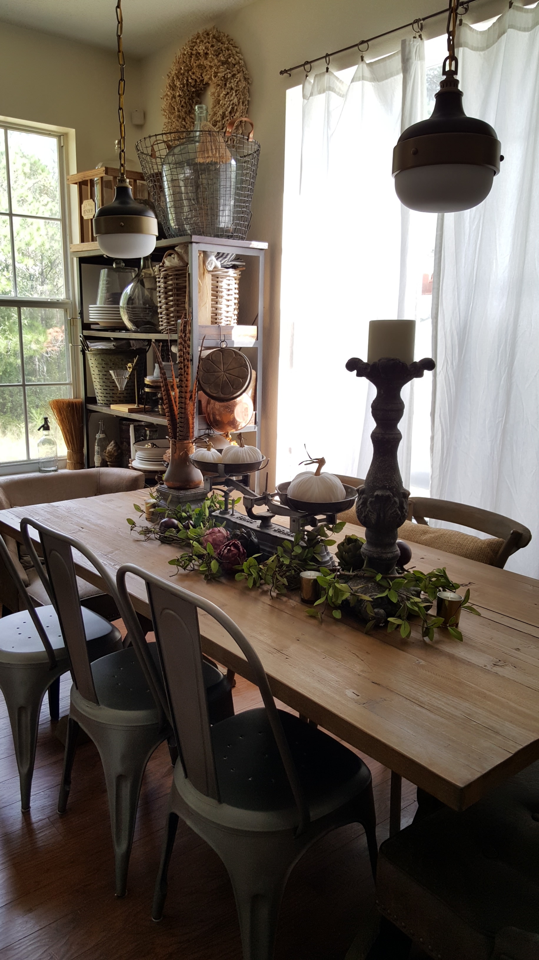 dining wood table white pumpkins pheasant feathers artichoke garland