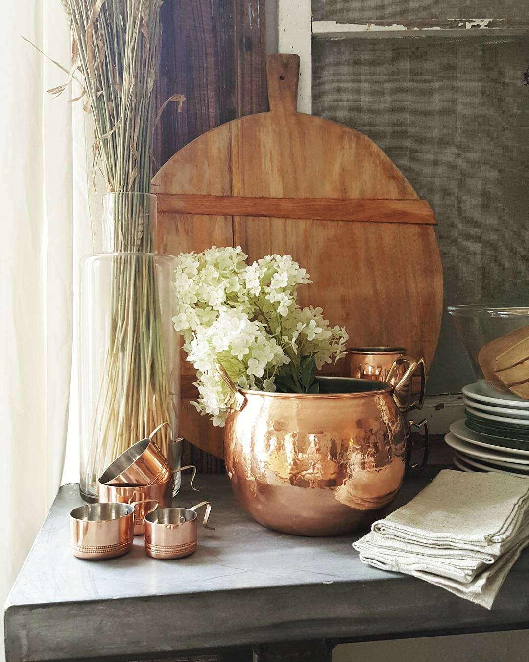 Country Farmhouse Kitchen White Tulips Flowers Wood Spoons Bread Boards Concrete Table Copper Hydrangea Metrie Moulding Molding Baskets Country Living Decor Design