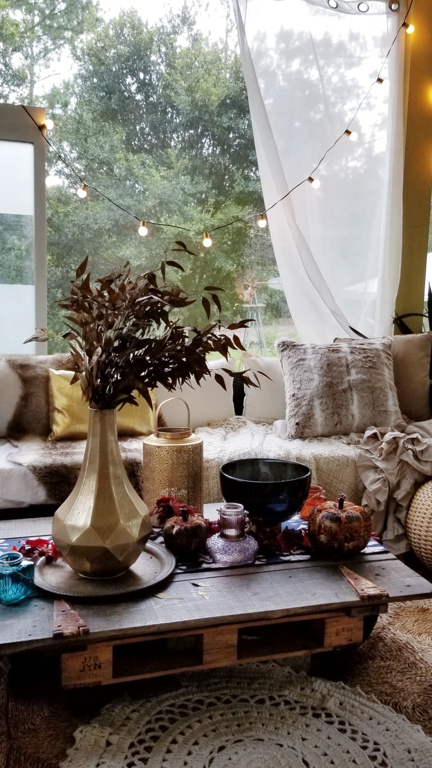 Fall At Home Decor Store Design Inspiration Back Porch Bohemian Eclectic Chic Boho Rustric retreat fur jewel tones pumpkins acorns gold lanterns candles throws pillows plants branches candles cozy wood autumn decor harvest vase macrame rug 