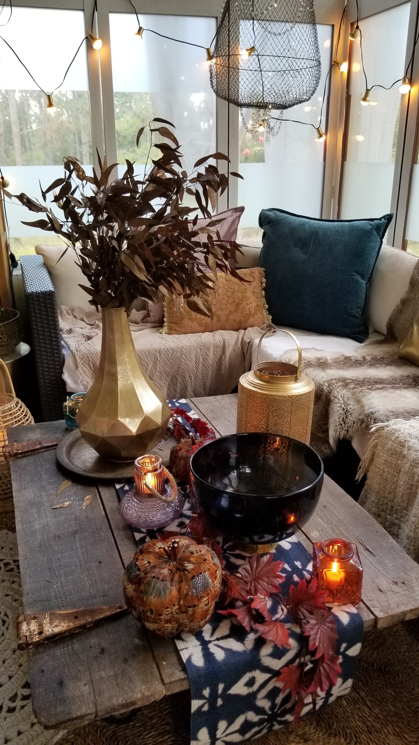 Fall At Home Decor Store Design Inspiration Back Porch Bohemian Eclectic Chic Boho Rustric retreat fur jewel tones pumpkins acorns gold lanterns candles throws pillows plants branches candles cozy wood autumn decor harvest vase macrame rug 