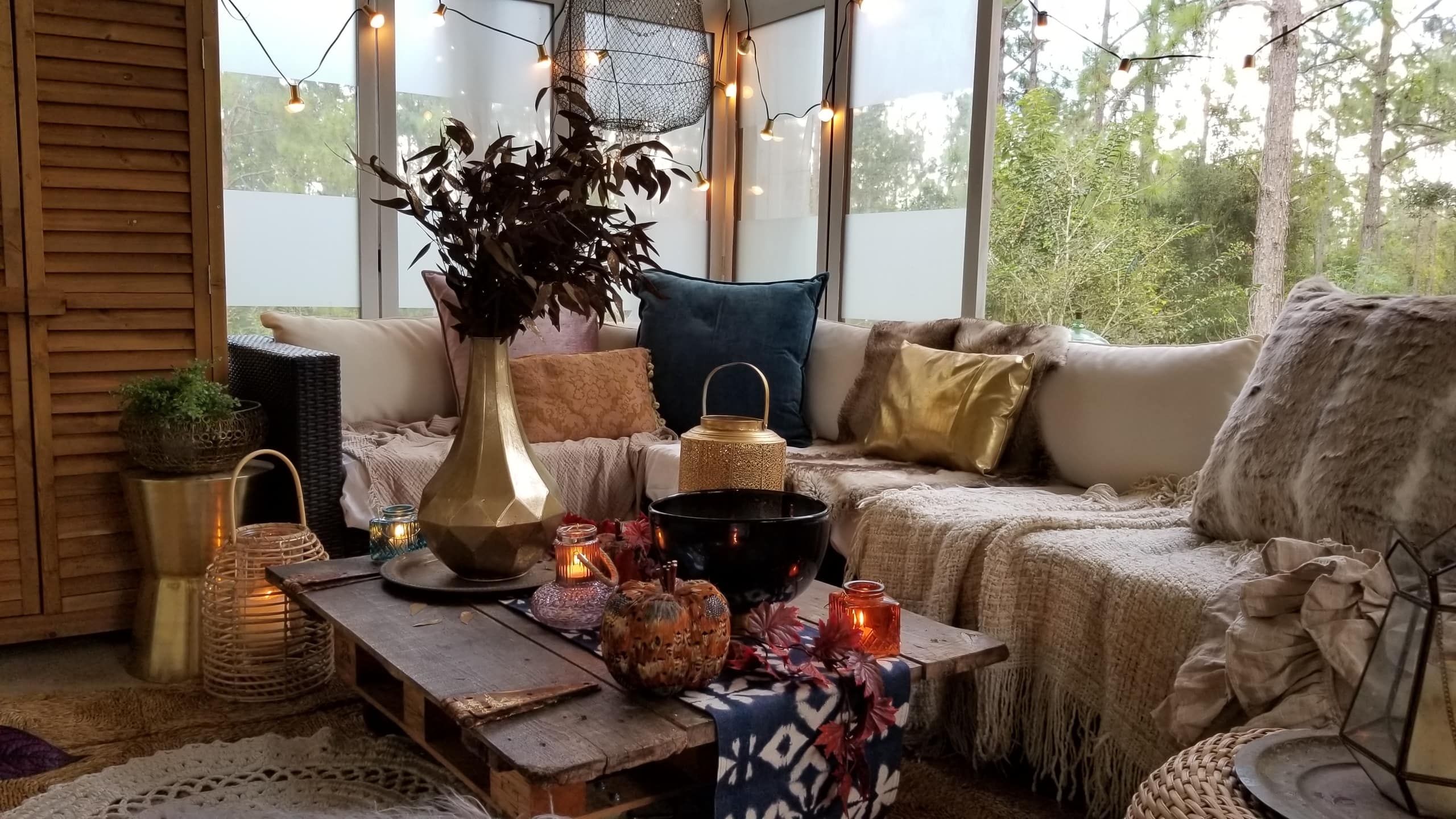 Fall At Home Decor Store Design Inspiration Back Porch Bohemian Eclectic Chic Boho Rustric retreat fur jewel tones pumpkins acorns gold lanterns candles throws pillows plants branches candles cozy wood autumn decor harvest vase macrame rug 