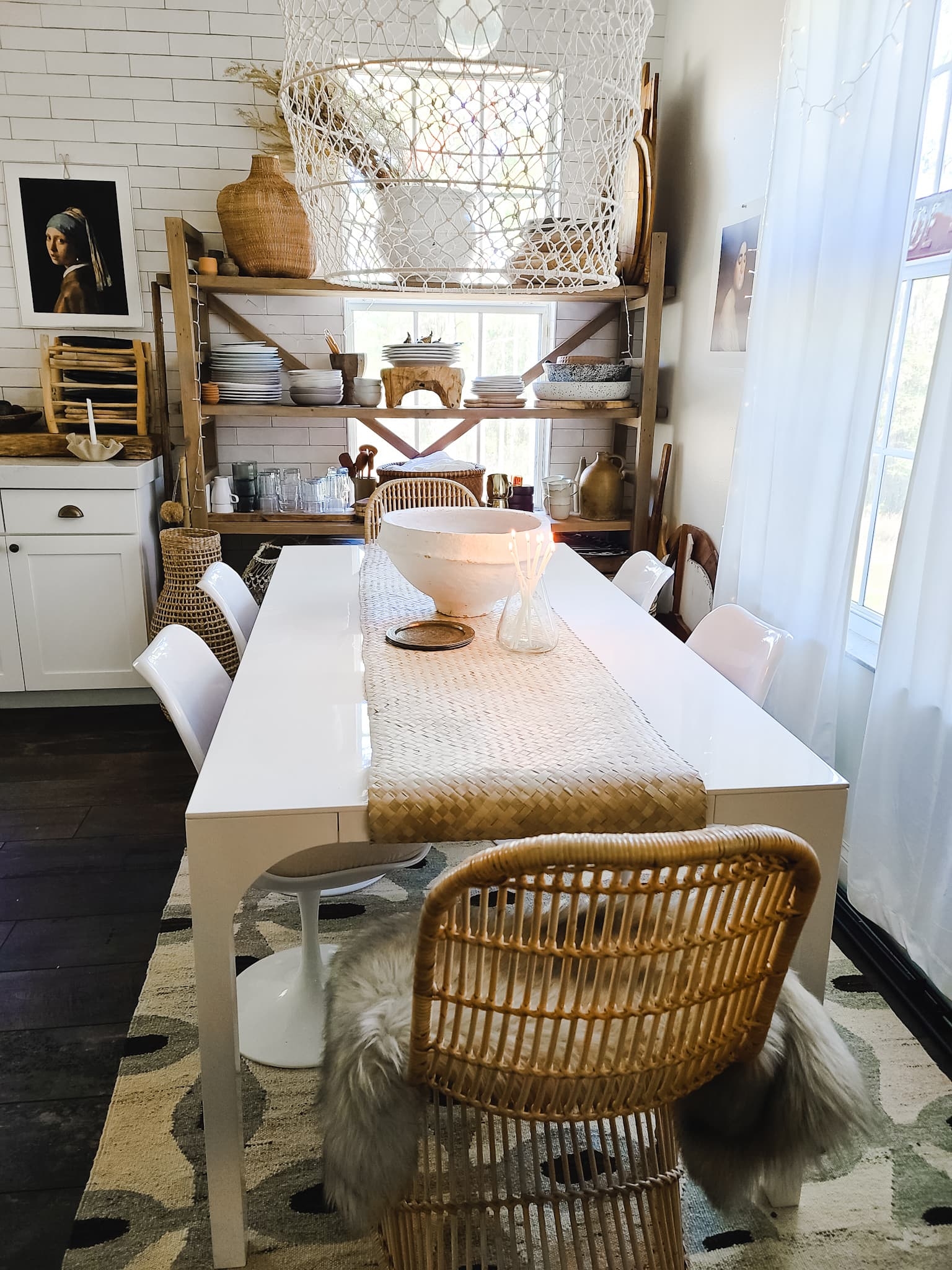 Scandinavian Modern Hygge style white dining room with candles texture woods and whites. Kitchen decor, vintage rugs, cane cabinet and open shelving.