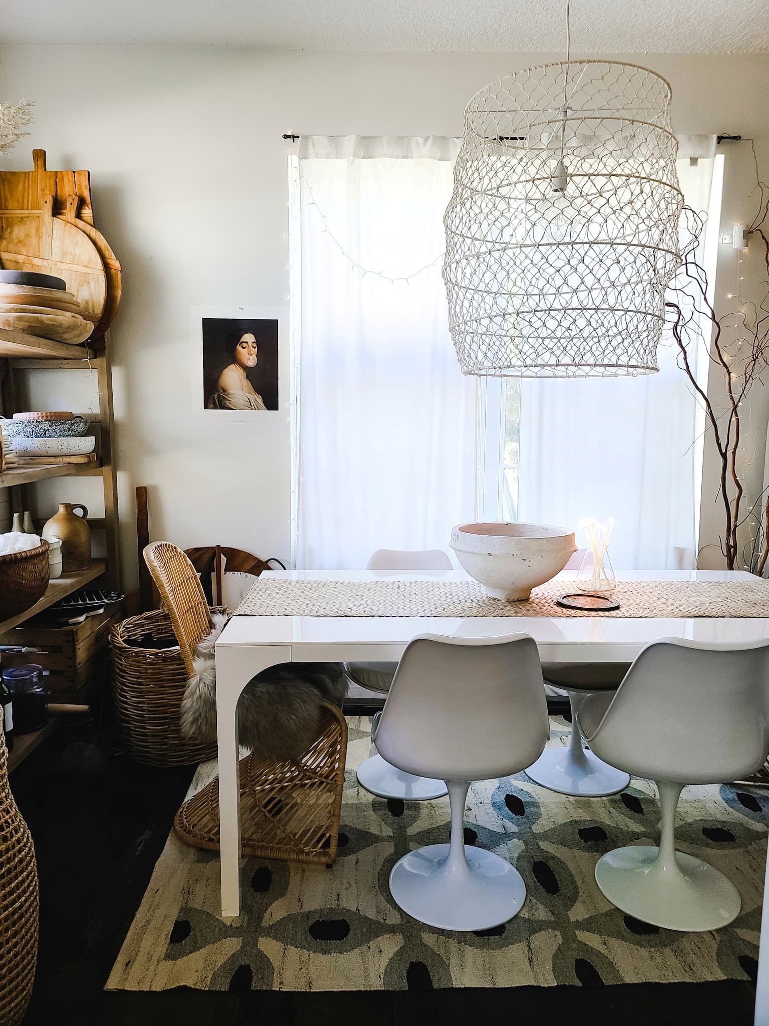 Scandinavian Modern Hygge style white dining room with candles texture woods and whites. Kitchen decor, vintage rugs, cane cabinet and open shelving.