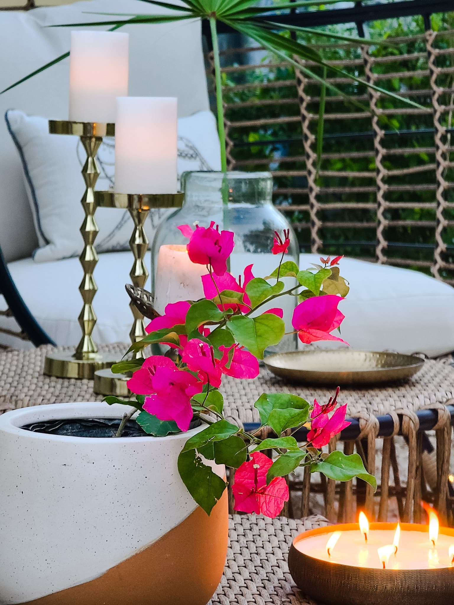 Backyard oasis patio egg chairs with wicker coffee tables gold accents flowers trees and boho chic decor